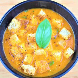 bowl of tomato soup with basil - roasted tomato soup with herbed croutons recipe